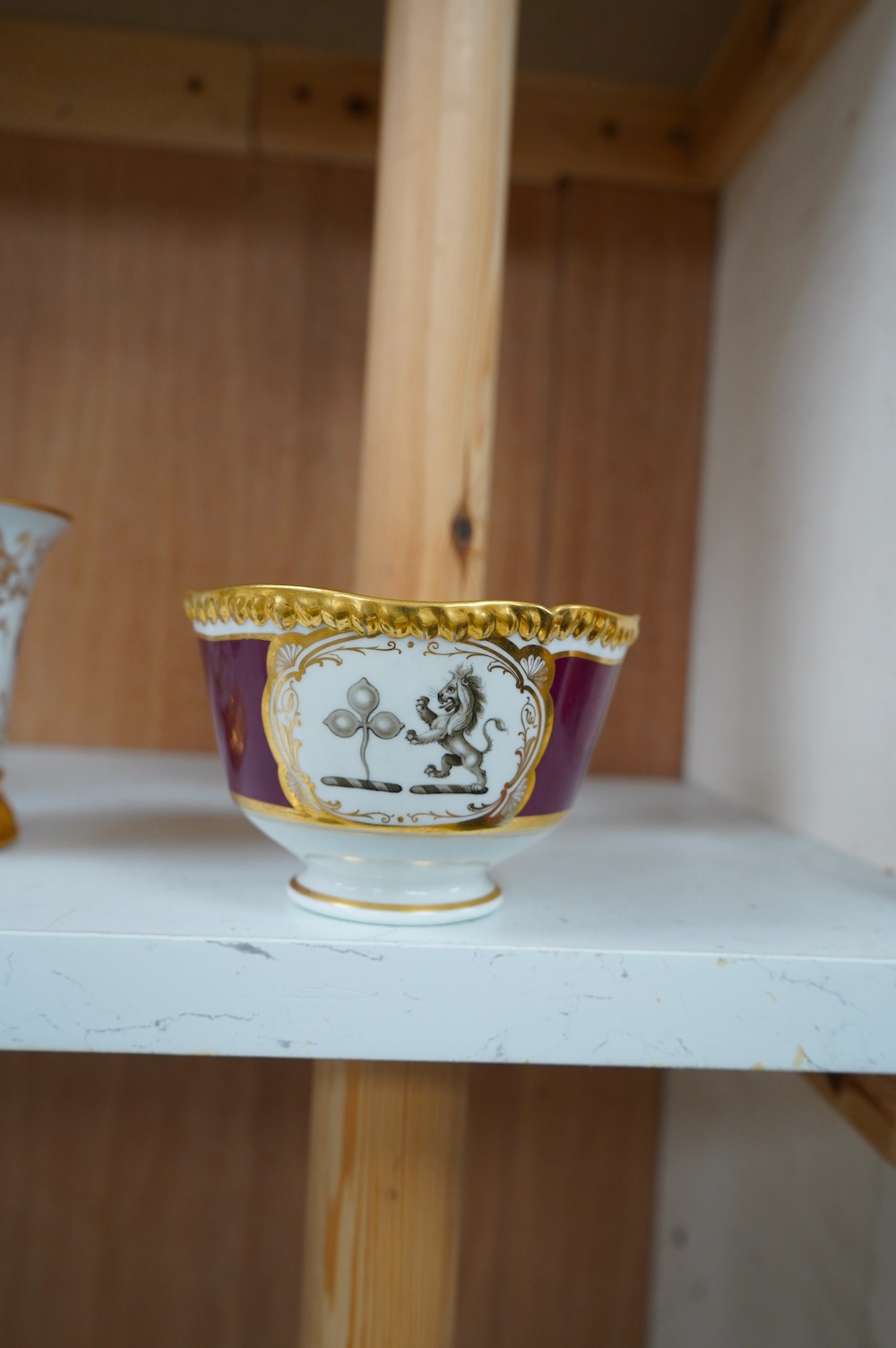 An armorial mug with lithophane figural scene to the base, together with a similar cup, largest 12cm high. Condition - mug poor, cup is good